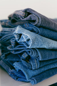 a-pile-of-denim-jeans-in-different-shades-of-blue